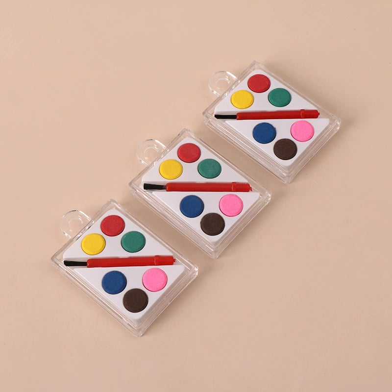 Six watercolor paint cakes and small brush in clear case